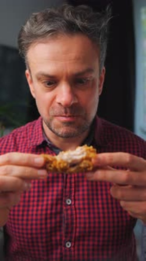 Man Enthusiastically Eating Crispy Fried Chicken in a Close-Up Shot