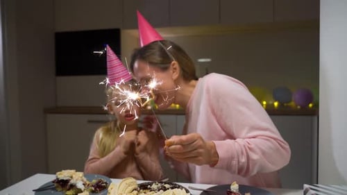 Mother and Child Celebrate Birthday with Sparkler Indoors
