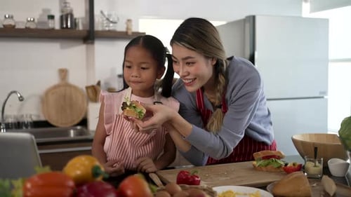 Woman and Girl Preparing Sandwiches Together in Kitchen