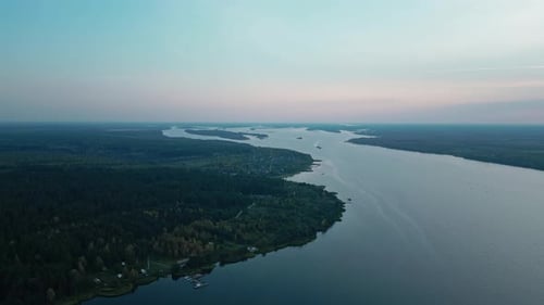 The Camera Flies High Over an Incredibly Large Winding River Towards Sunset