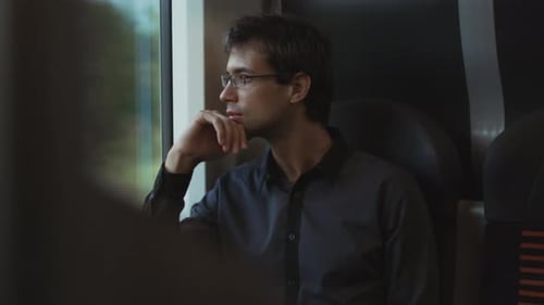 Man Looking through Window in Moving Train