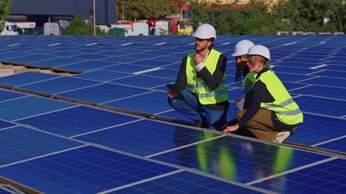 Ingenieurteam inspiziert Sonnenkollektoren auf einem Dach