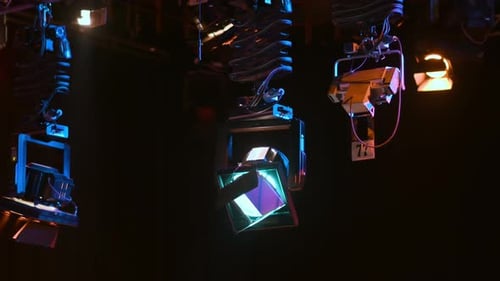 Grid of professional lighting fixtures suspended in a dark television studio