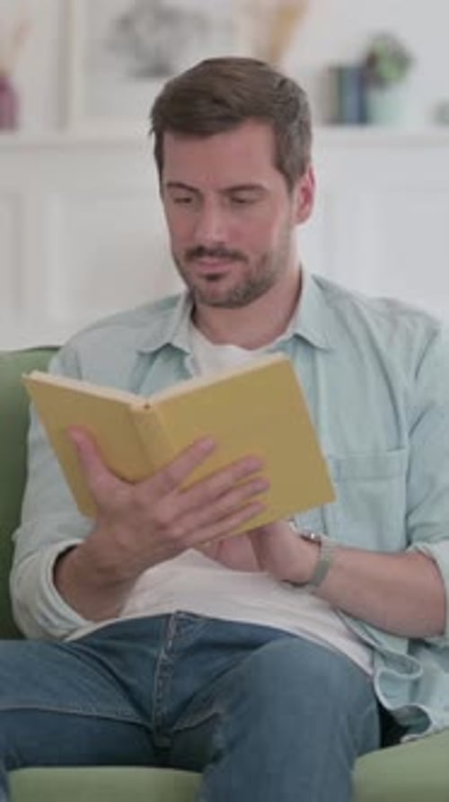Thoughtful Man Reading a Book Indoors During the Day