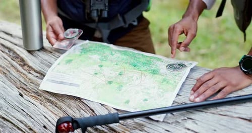 Map, hands and hike of people with compass, direction and travel with guide in nature for trekking