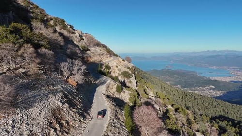 Aerial View of a Mountain Road with a Coastline in the Distance