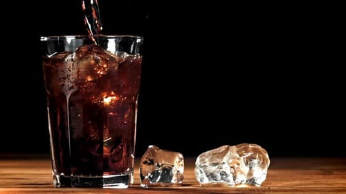 Soda Being Poured in Glass with Ice