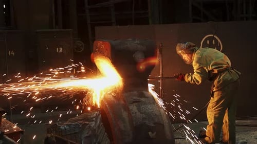 Factory Worker Cutting Metal with Tool Sparks