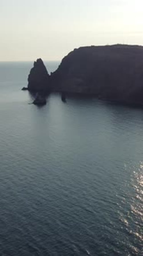 Aerial Vertical View of Beach with Wave Caressing Shore Sun Glare Small Waves on the Water Surface