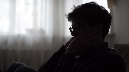 Trauriger Mann sitzt während der Krise auf dem Schlafzimmerboden: Konzept der Tragödie einer Depressionskrankheit