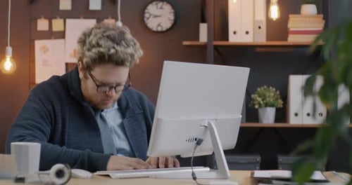 Loop of Sleepy Young Employee Using Computer and Falling Asleep Working Overtime Late in Evening in