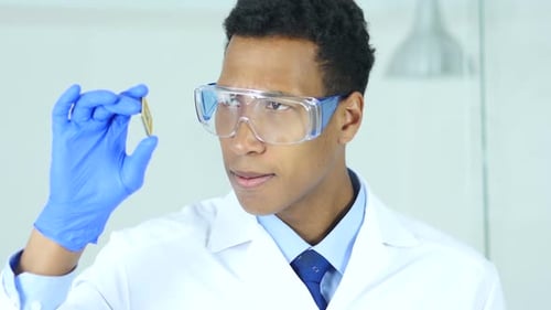 Erstaunter Wissenschaftler hält und untersucht die Suche nach einem neuen Computerchip
