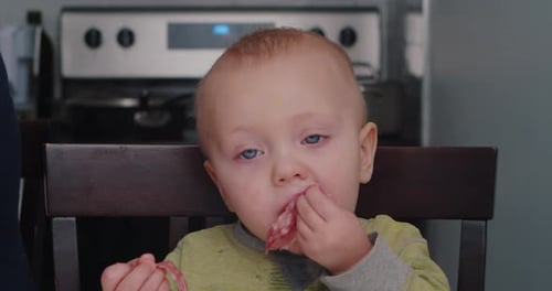 Cute Baby Eating Snack in Kitchen