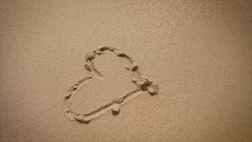 Drawing a Heart in the Sand at the Beach