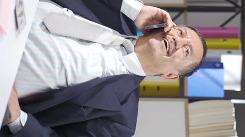 Adult Businessman Talking on Mobile Phone in Office