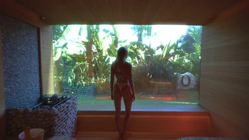 Woman relaxing body and mind in sauna room.