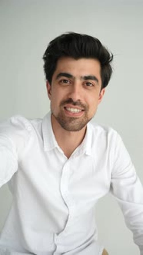 Smiling Young Adult Man Talking Indoors