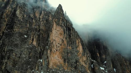 4k Drone Low Angle Upward Pan Shot Of Jagged Sharp Rock Peak Of Dolomite Mountains In Northern Italy
