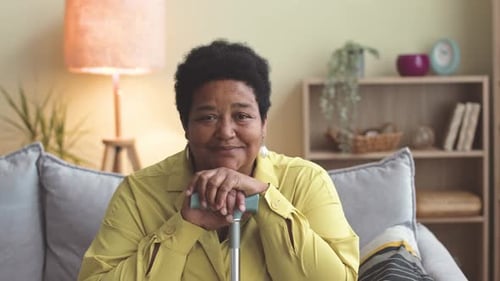 Smiling Senior Woman Resting with Walking Cane Indoors