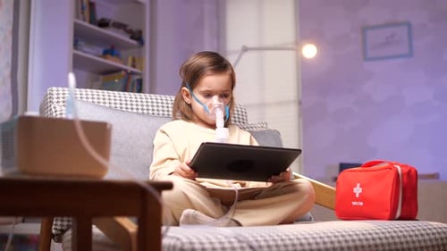 Girl Using Nebulizer Mask While Looking At Tablet