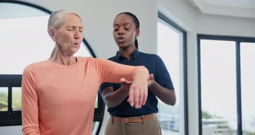 Senior Woman Exercising Arm With Therapist