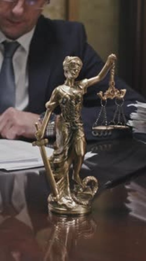 Male Lawyer Busy with Paperwork at Desk in Office