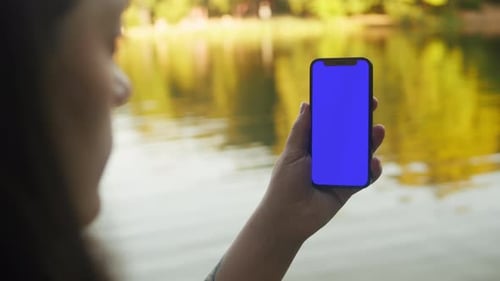 Young Woman with Cellphone Chroma Key Screen in the Lovely Park Closeup Girl with Green Screen on