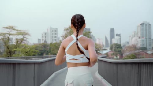 Young fitness woman in sportswear jogging in city park