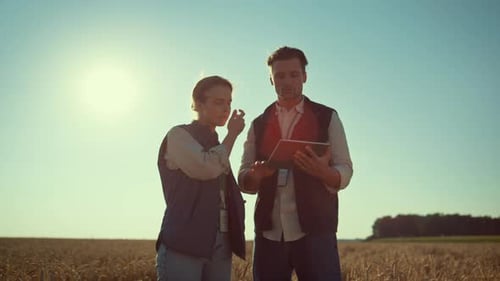 Farmers in field looking at a tablet device