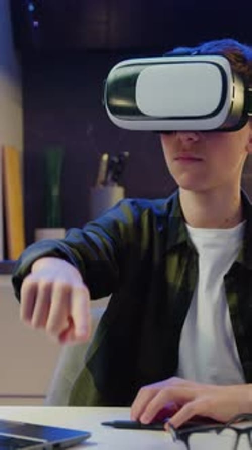 Teen Blond Caucasian Boy in VR Glasses Sitting in Evening Kitchen and Having VR Headset Male Moving