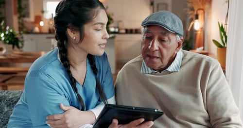 Senior Man Receives Tablet Help From Young Woman