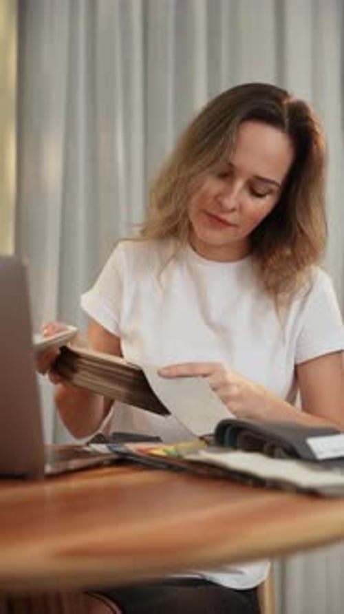 Woman Reviews Fabric Swatches at Wooden Table