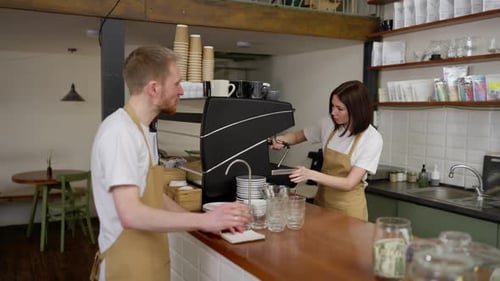 Baristas working behind the counter in a cafe