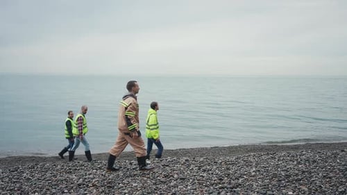 a Group of People Volunteers Searching for a Missing Person on the Beach By the Water or Ocean