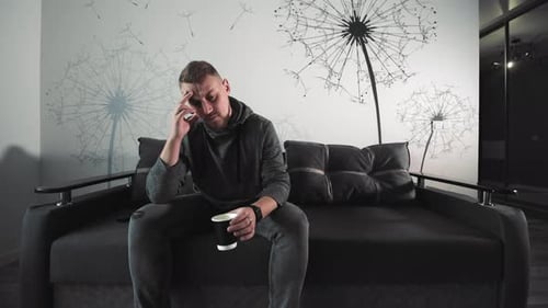 Man with Headache Holding Coffee Man in Thoughtful Pose with Coffee Experiencing a Headache or