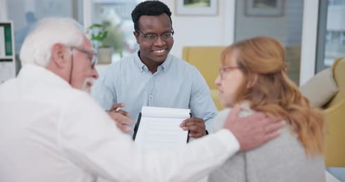 Consultant Reviews Paperwork with Senior Couple in Office