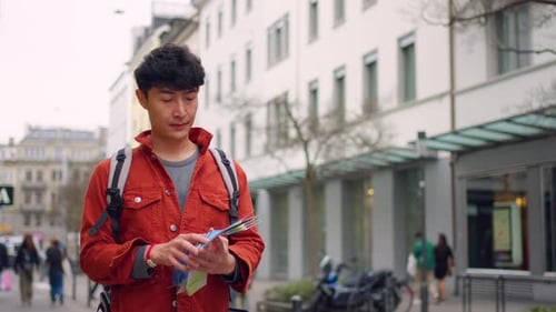 Asian attractive man backpacker walking around beautiful road in city.