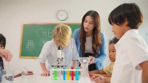 Adorable student learn with teacher in classroom at elementary school. Young brilliant and smart chi