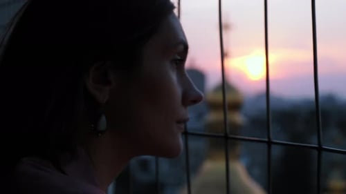 Cinematic Portrait of a Beautiful and Sad Woman Looking at a View of Orthodox Domes at Sunset and