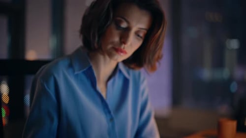 Woman Working at Desk at Night in Office