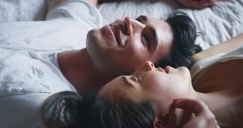Slow motion close up of young couple is relaxing in the bedroom in the early morning in a sunny da