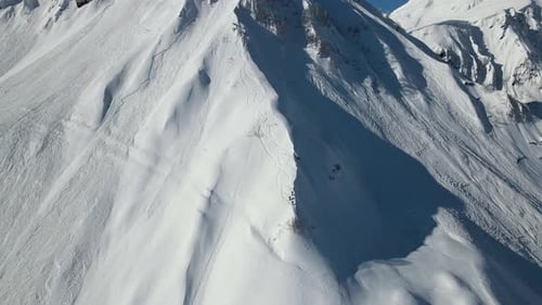 Survolez les pentes des hautes montagnes avec les marques laissées par les skis et les snowboards