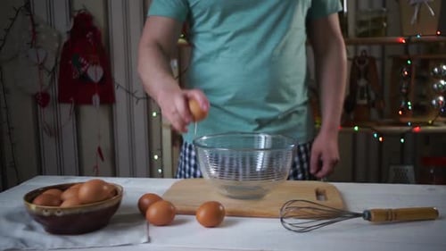 Man Cracking Eggs into Bowl in Decorated Kitchen