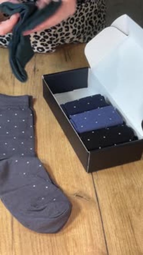 Arranging Socks from Box on Wooden Table Top