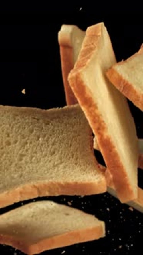 Pieces of Fresh Bread Fly Up Against a Black Background Filmed on a Highspeed Camera at 1000 Fps