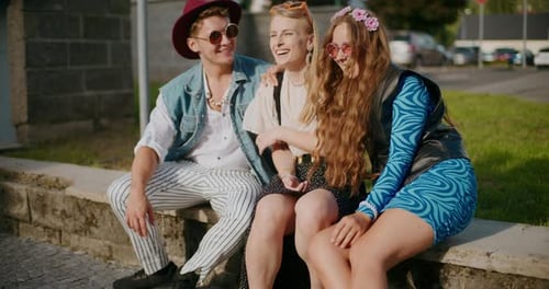Young Friends Laughing While Sitting on Bench