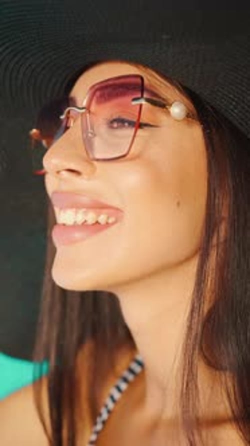 CloseUp of Woman Enjoying Drink By Pool in Sun Hat