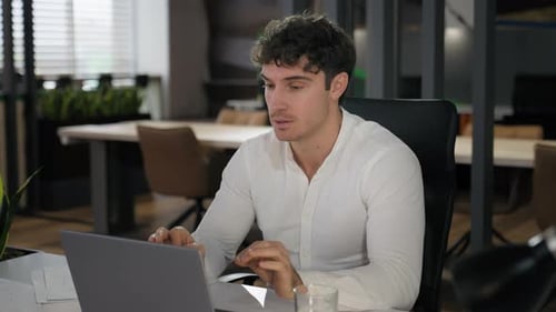 Man Working on Laptop in Modern Office