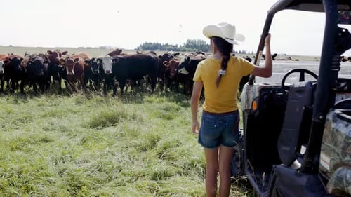 Girl in Cowboy Hat Getting Out of Quadbe on Cattle Ranch 10 Seconds or Greater