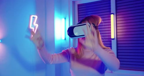 Gamer in VR headset glasses exploring metaverse plays online video game touching something